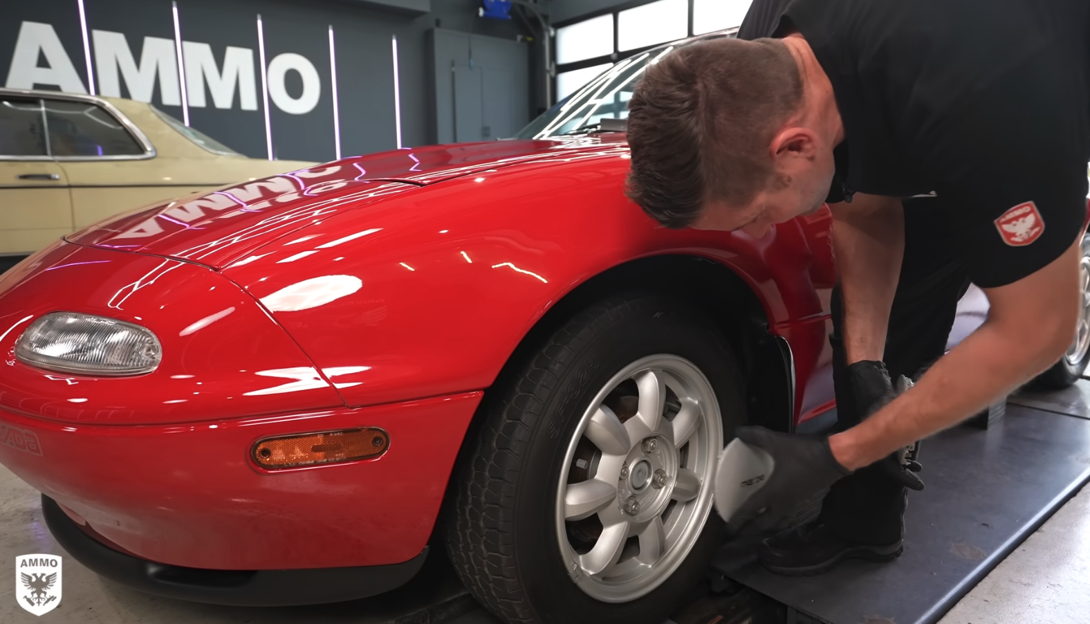 Larry Kosilla cleans a 1990 Mazda Miata