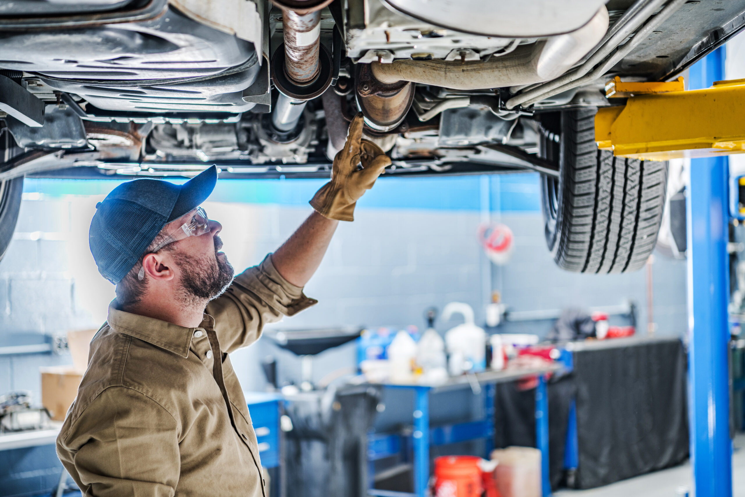 mechanic looking at underside of car